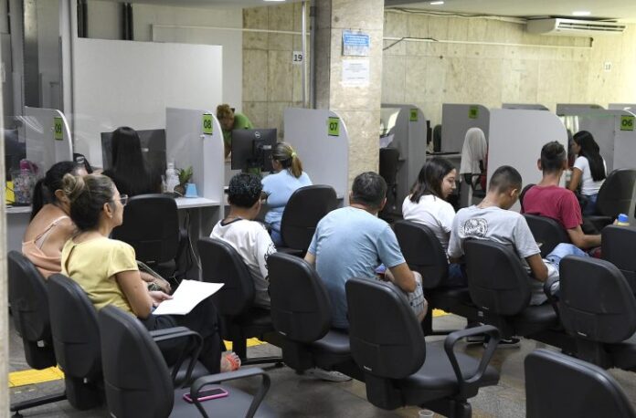 Homens e mulheres esperam atendimento em frente aos guichês de atendimento da Funtrab